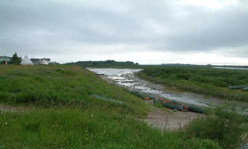 Pictured here is the Attawapiskat River at low tide.  Notice the freighter canoes beached on the bank of the river at the edge of Attawapiskat First Nation